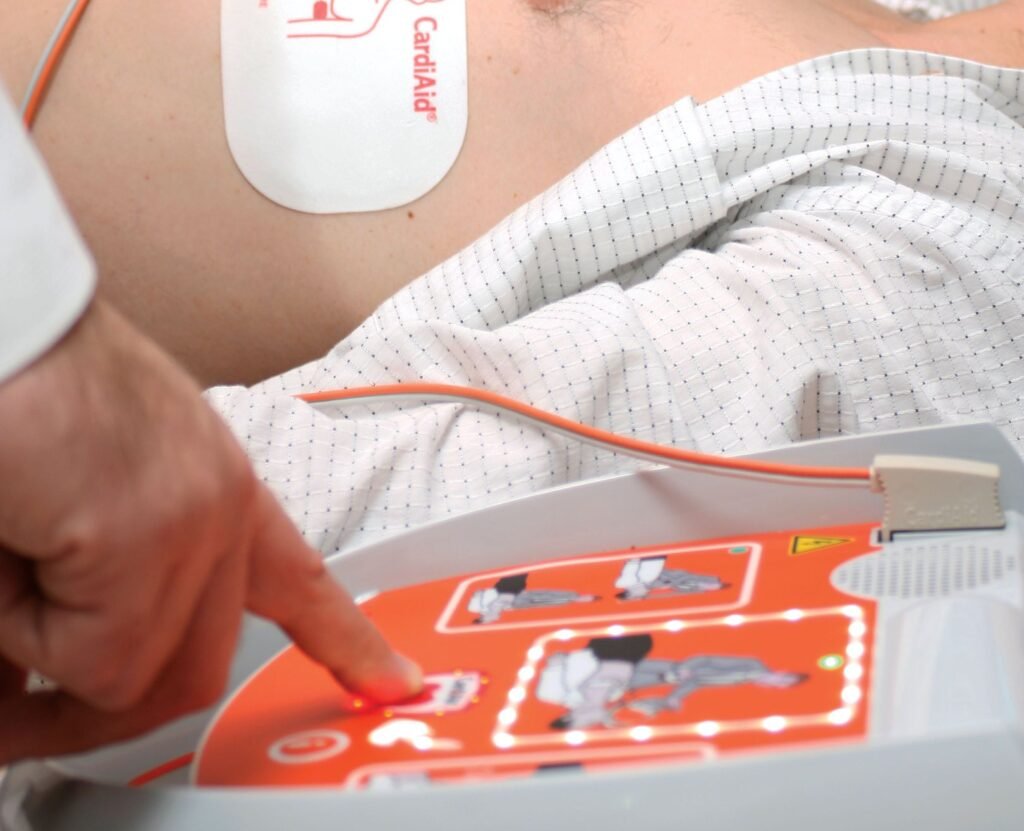 CardiAid defibriliatoriaus naudojimas – šoko mygtuko paspaudimas